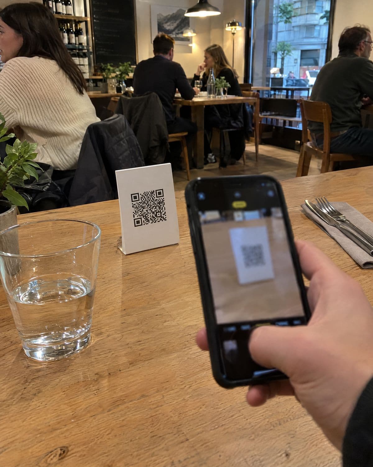 Gast scannt den QR-Code am Restauranttisch mit dem Handy